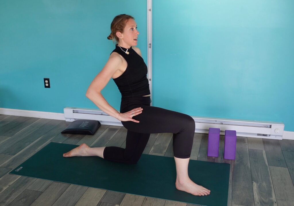 Dr. Chloe in a split kneeling stance with her right leg in front, left knee on the ground. She is stretching her hip flexor on the left side